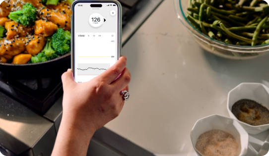 Dexcom CGM user looking at the Dexcom G7 app while cooking